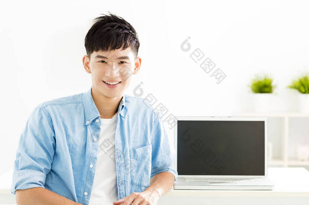 与笔记本<strong>电脑</strong>的亚洲年轻男人微笑着