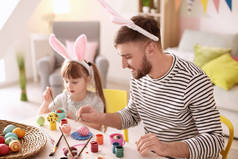 父亲在餐桌上画复活节彩蛋与他的女儿