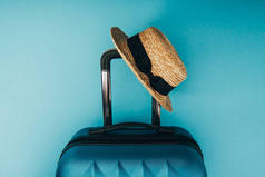 在蓝色背景草帽和旅行袋的顶视图