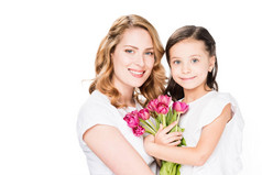 幸福的母亲和小女儿的肖像与花束的花朵隔离在白色, 母亲节假期概念