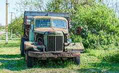 绿色春田上的老旧生锈的卡车
