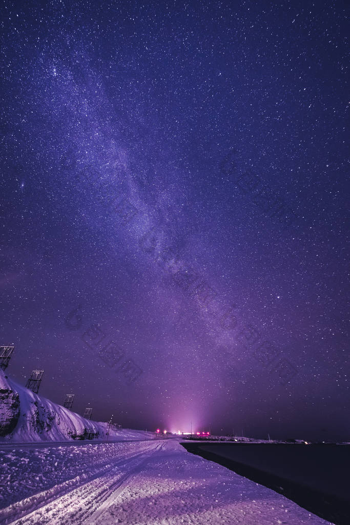 与多彩银河系和黄灯在山的夜景观。满天星斗的天空，在夏天的小山。美丽的宇宙。空间背景