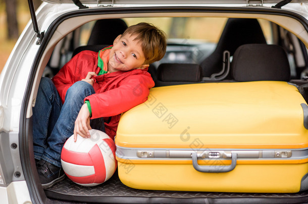 微笑<strong>的男孩</strong>坐在汽车后备箱
