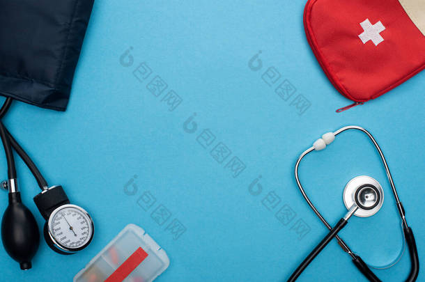 容器、血压计、急救箱及蓝色背景听诊器内的药丸头像