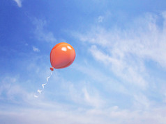 在蓝色的天空中单橙色气球