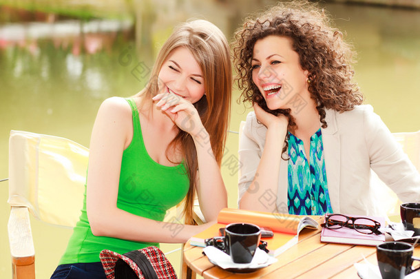 在江边的露台咖啡笑的两个漂亮女人