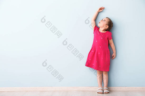 小女孩测量高度近墙