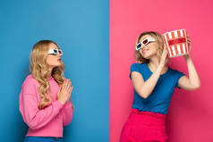 戴3D眼镜的金发女孩，双手紧握着祈祷者的手，微笑着，带着蓝色和粉色背景的爆米花