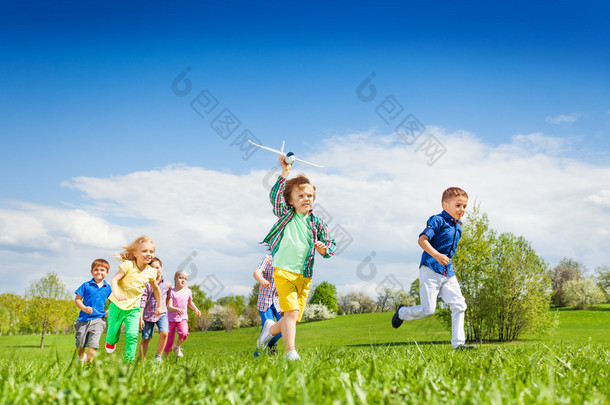 Running boy with airplane toy and children
