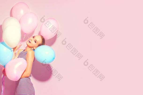 愉快的少女与五颜六色的空气气球有乐趣在<strong>粉红</strong>色背景