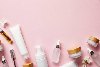 奶油管，化妆品分配器，空罐子和手霜，粉红色的玛斯卡拉瓶的顶视图 图片