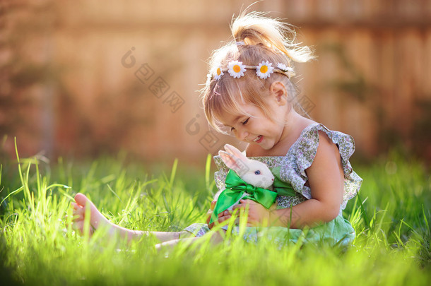 可爱的小女孩与小<strong>兔子</strong>有一个复活节在绿草