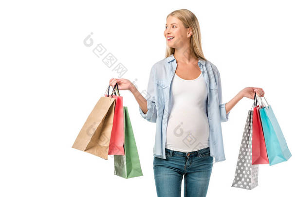 美丽的愉快的孕妇持有的购物袋查出的白色