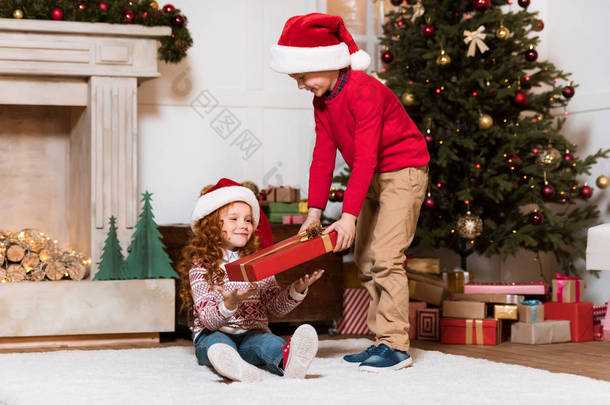 孩子们在礼物的圣诞老人帽子