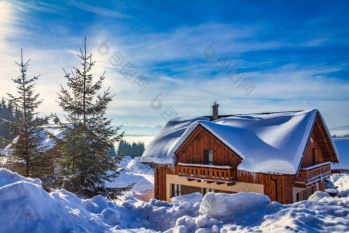 冬季景观，有雪地覆盖的木制山舍.