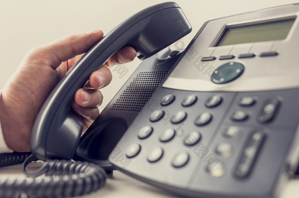 Closeup of male operator about to answer a phone call