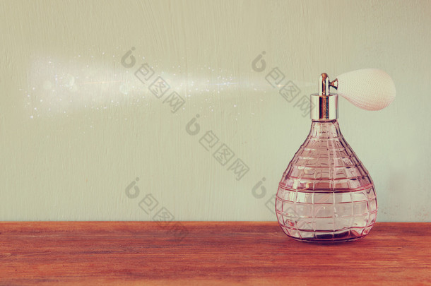 老式古董香水瓶与影响香水喷雾器，木制的桌子上。复古的滤波的图像