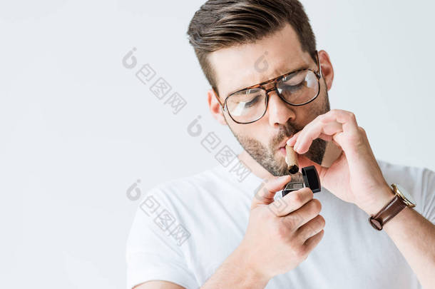 英俊的胡子男子在眼镜照明雪茄孤立的白色背景