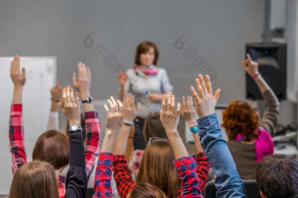 活跃的学生高举双臂准备好要回答老师的问题 