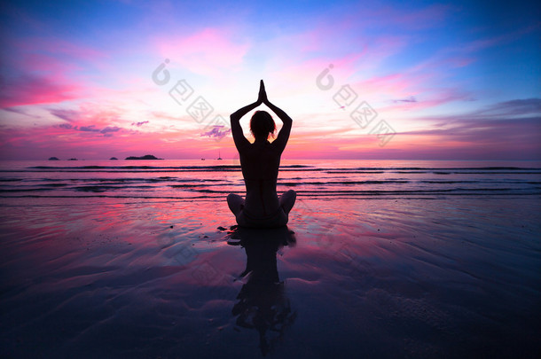 落日瑜伽女子在海滨