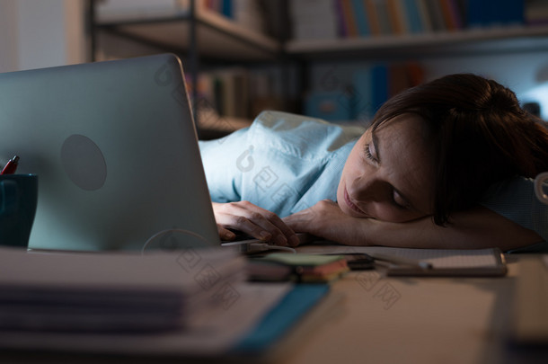 疲惫的女子睡附近笔记本电脑