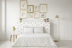 床头床上的花纹床上用品桌上有粉红色花的妇女卧室内饰