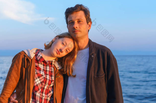夏天在贝加尔湖岸边日落时的父亲和女儿肖像