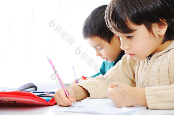 两个可爱的学校男孩一起工作对他们的家庭作业