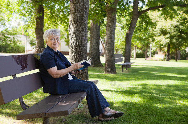 在一个公园的女人阅读本书
