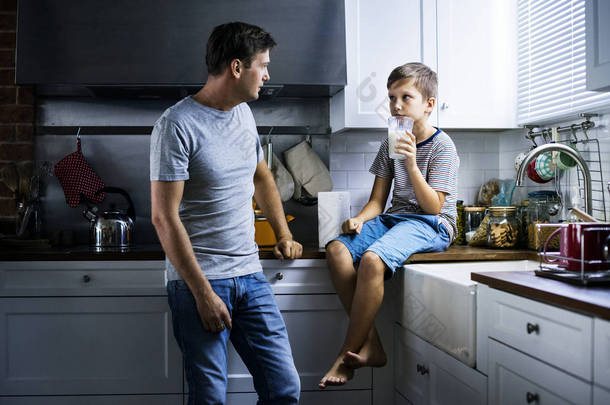 父亲<strong>和儿子</strong>在厨房, 男孩拿着玻璃牛奶
