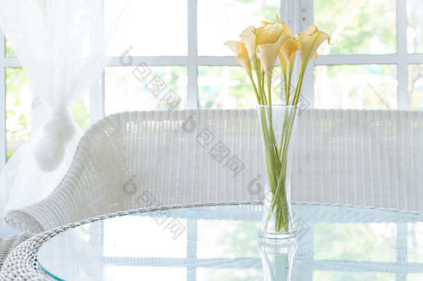 表和窗窗台背景上的花瓶<strong>中</strong>的黄色花。文塔