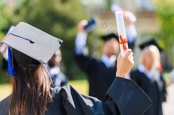 毕业的学生<strong>女孩</strong>的后视图与文凭问候同学