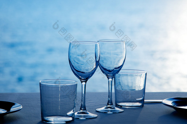 玻璃盘子杯子和眼镜的蓝色的大海