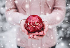 手里拿着圣诞红球的女人多雪的森林里寒冷的冬日.圣诞快乐，新年快乐