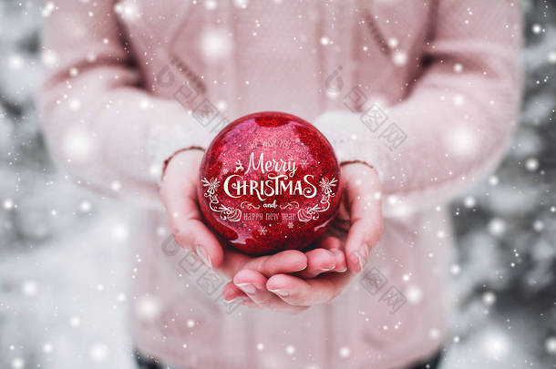 手里拿着圣诞红球的女人多雪的森林里寒冷的冬日.圣诞快乐，新年快乐