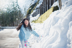 亚洲女孩在雪中户外微笑在寒冷的冬天里