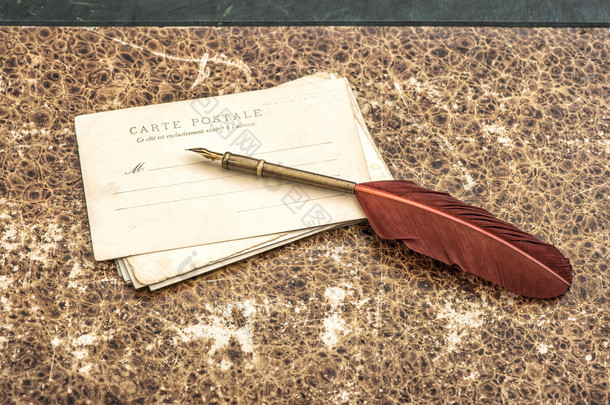 Vintage still life with old post cards and feather pen. Retro st