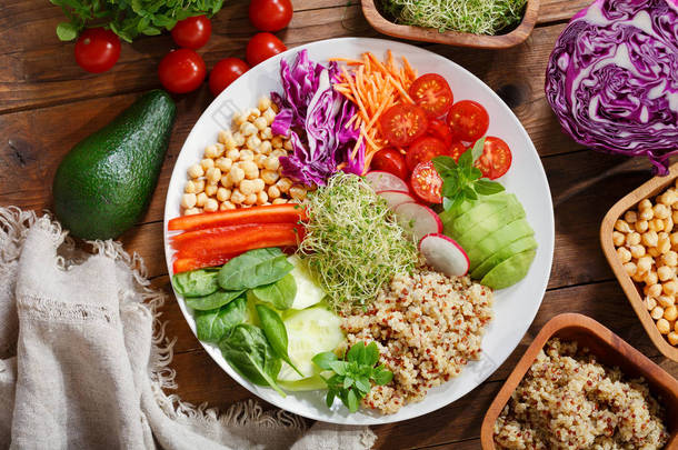 素食。健康沙拉用鳄梨, 藜麦, 西红柿, 胡椒, 菠菜, 卷心菜, 芽和鹰嘴豆, 顶部视图