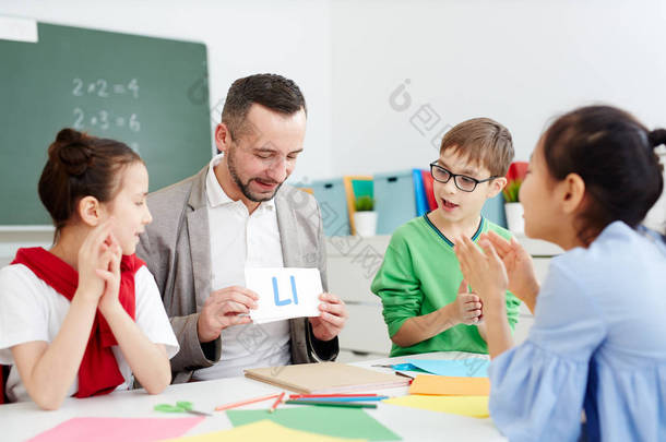 有信心的中学中年英语教师在课上显示他的<strong>学生</strong>卡片和信件