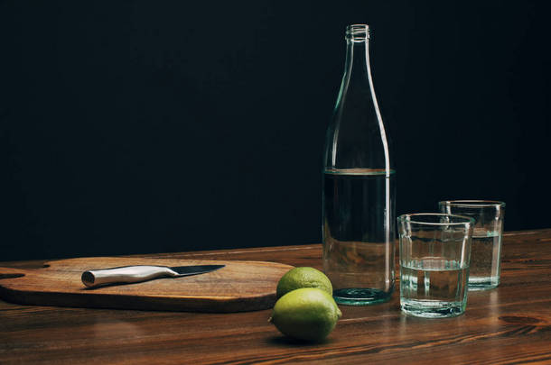 木制餐桌用刀、酸橙、瓶装水的木板