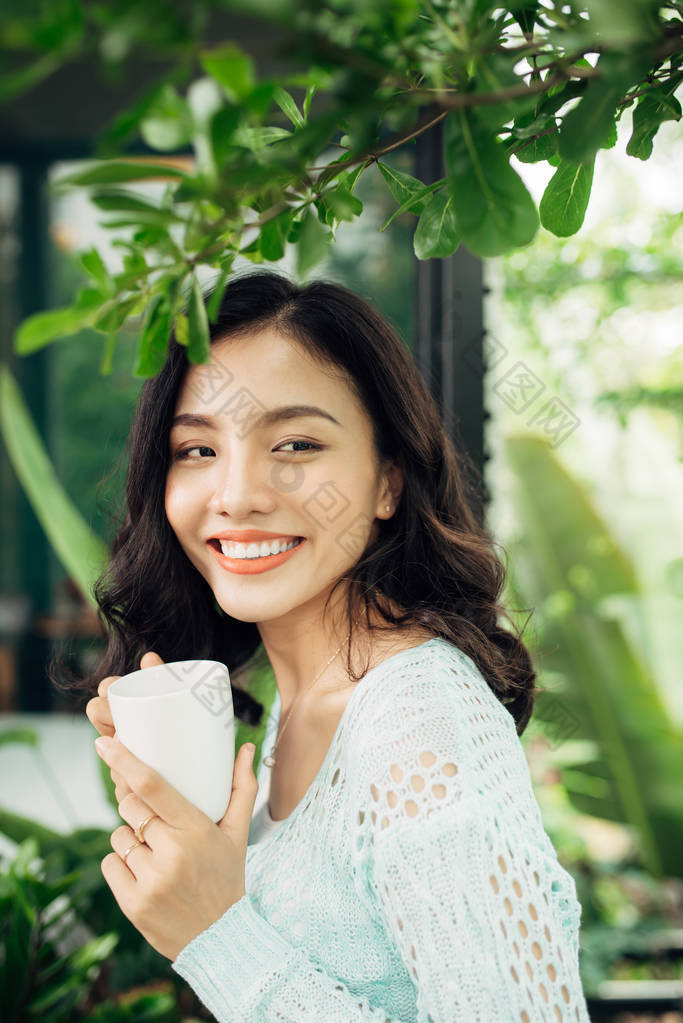 年轻的亚裔女子和杯子