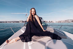 一个穿着黑色夏装的豪华小女孩在白色游艇上享受假期, 喜欢旅行。