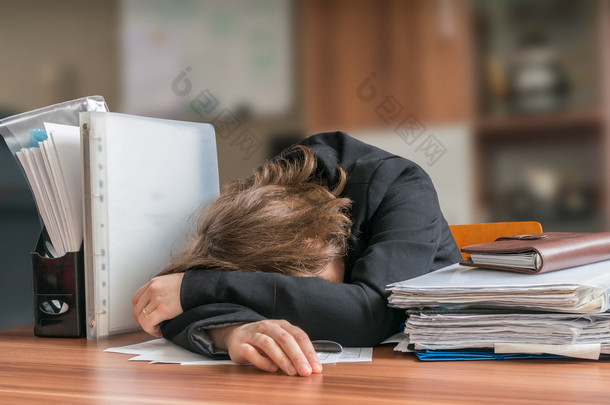 <strong>懒惰</strong>的业务女子睡在办公室的桌子上.