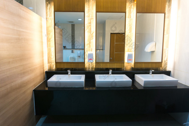 商业浴室配有三个水槽和镜子