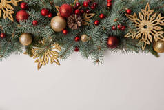 杉木树枝与圣诞节玩具和金色的雪花查出的白色的顶部视图