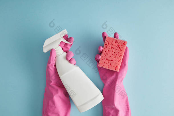 穿着粉色橡胶手套、拿着海绵和蓝色喷雾瓶的女管家的剪影