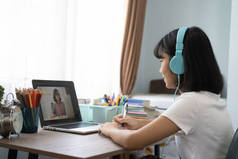 亚洲女孩在家在线学习作业，社会距离在线教育理念