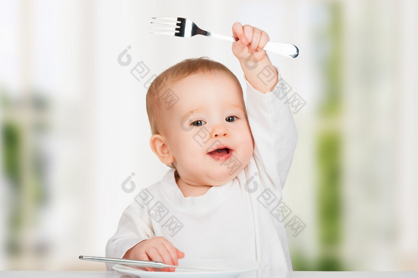 有趣的婴儿用刀叉吃的食物