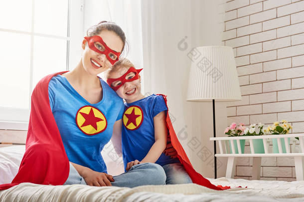 女孩和妈妈在超级英雄的服装