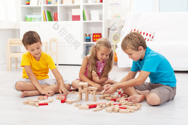 三个孩子玩玩木制积木